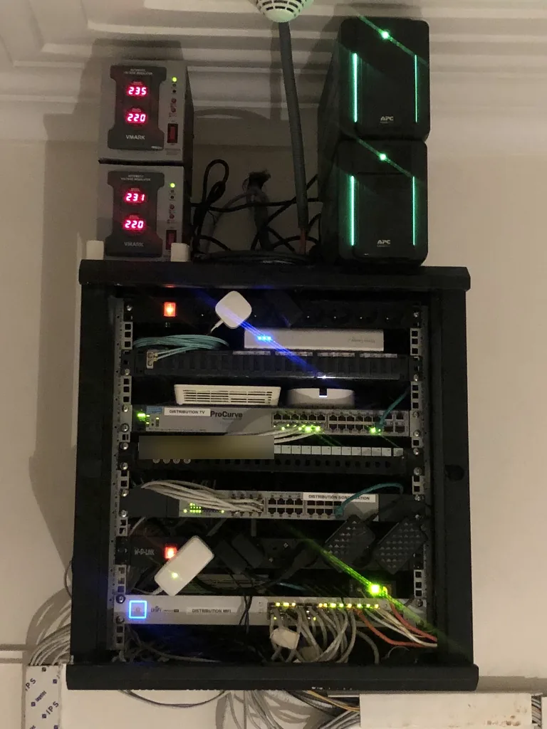 Villa, distribution rack. One switch per use, labelled Wi-Fi, television and sound. UPS units and voltage regulators above the rack.